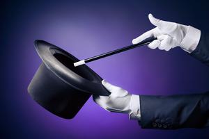 white-gloved hands holding a black hat and a wand