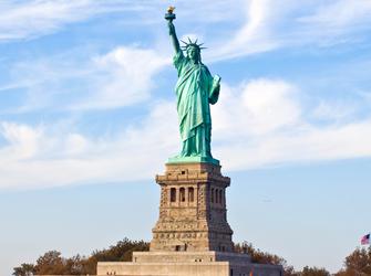 a large statue of a woman holding a book and a torch