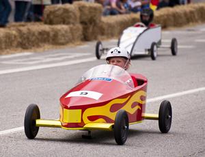 children racing in wooden cars