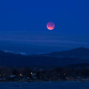 The full moon glows red in the night sky.